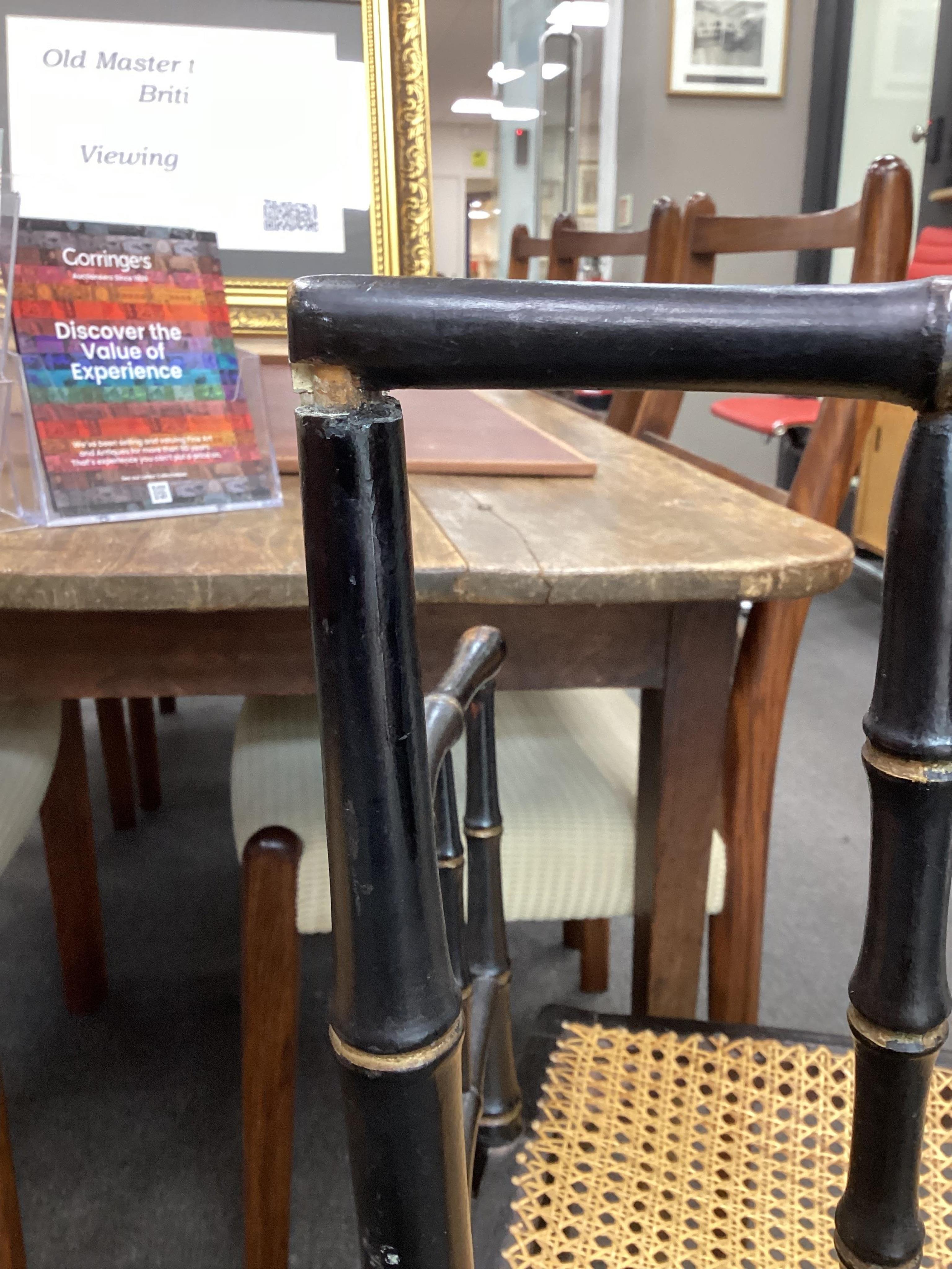 A set of four Regency ebonised simulated bamboo cane seat elbow chairs, width 56cm, depth 43cm, height 86cm. Condition - fair (one stretcher detached but present)